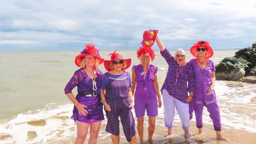 Five people on the beachThe winning photo of North Norfolk’s Age Positive Photography Competition. ’Red Hat Ladies’ by Sally Redgrave.