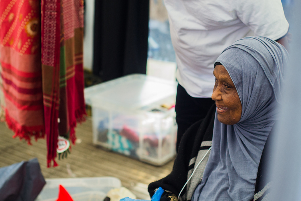 older worker sitting by stall