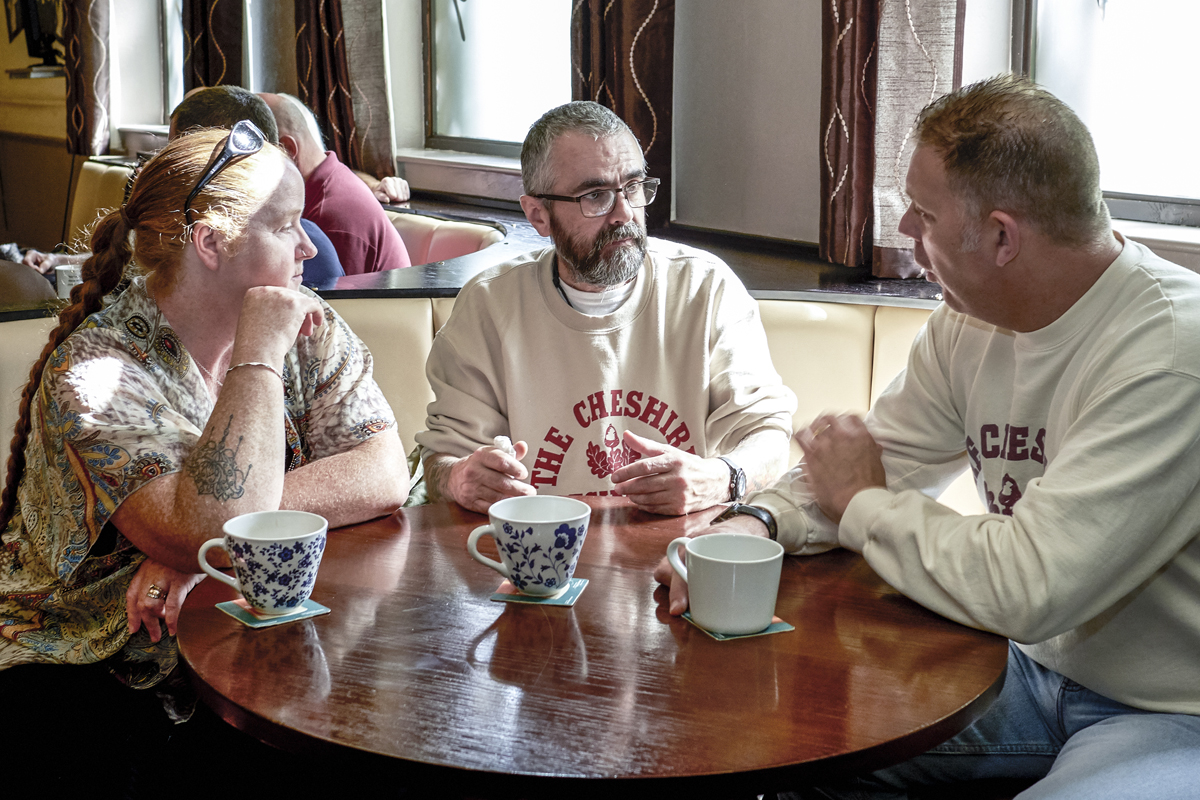Three people talking around a table