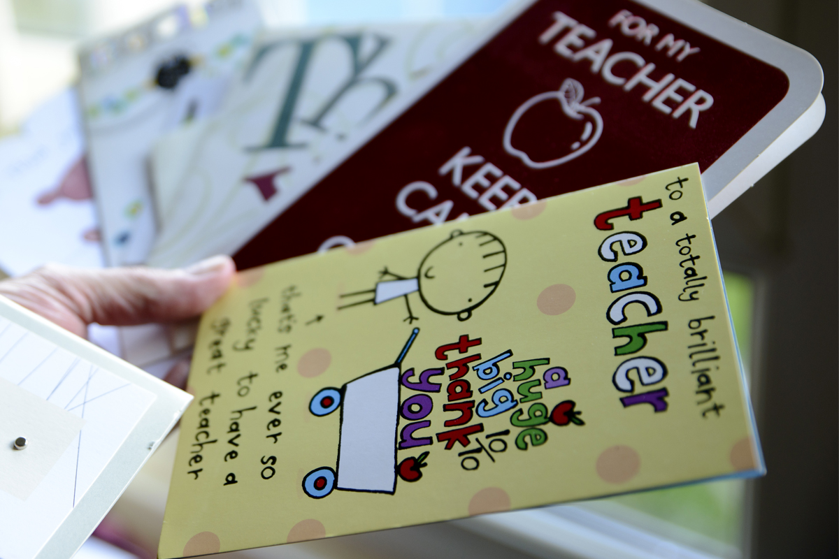 Teacher holding 'thank you' cards