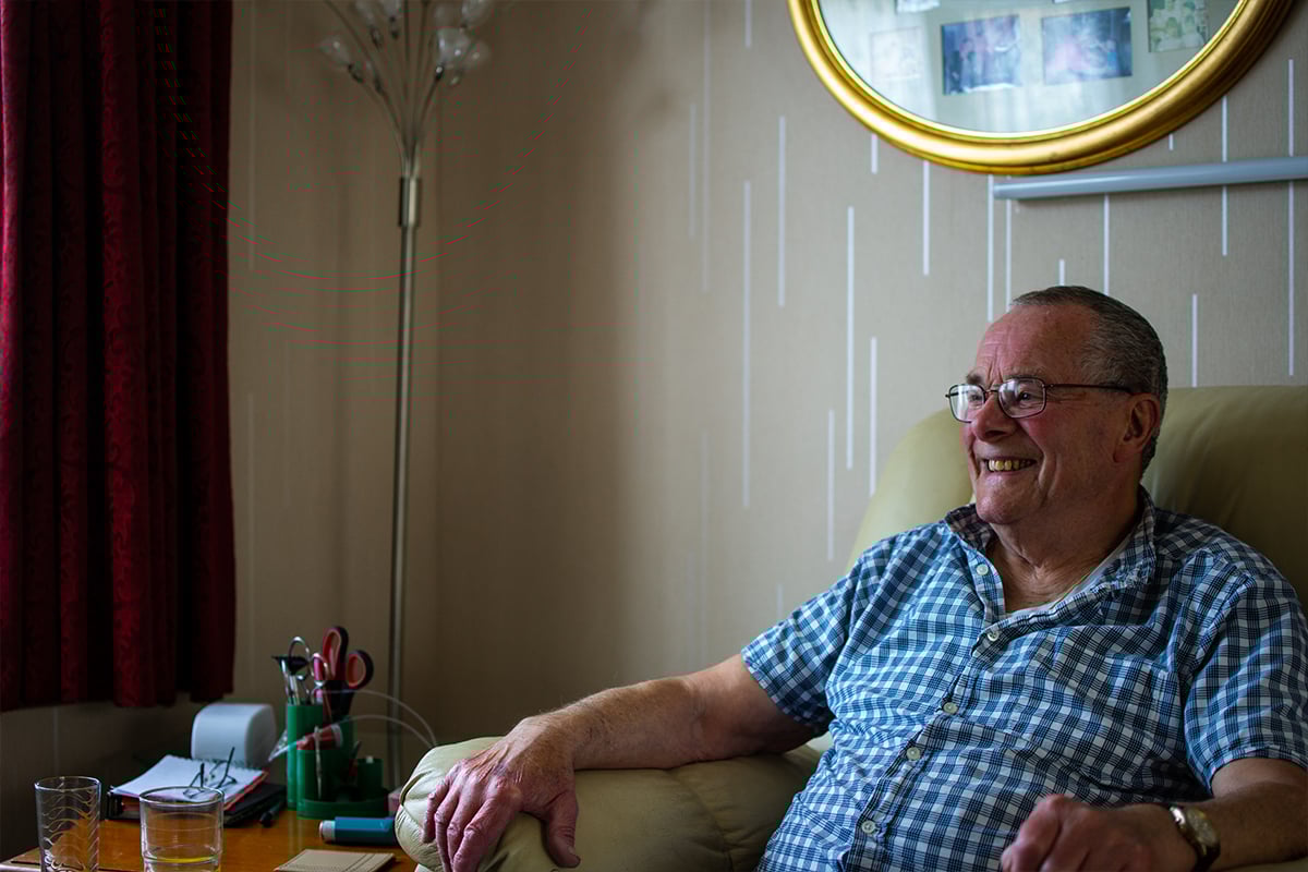 Older man sitting on chair in home
