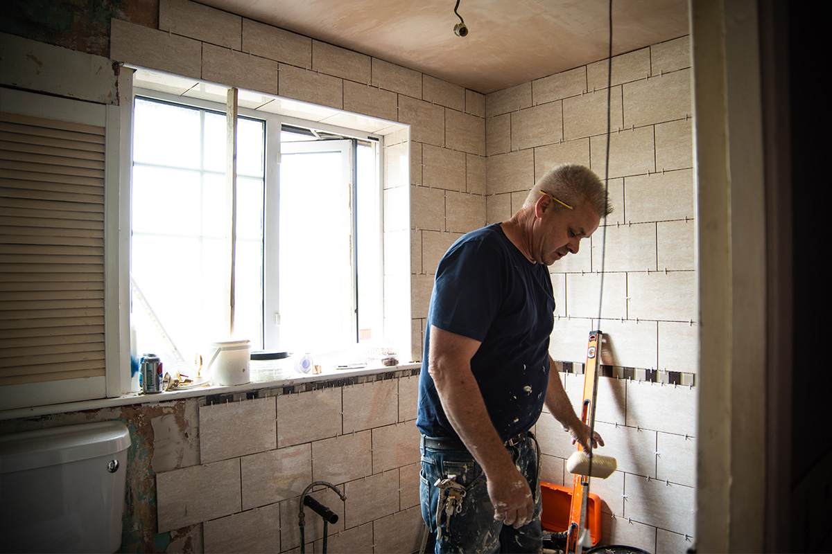 Worker making adaptations to a bathroom.