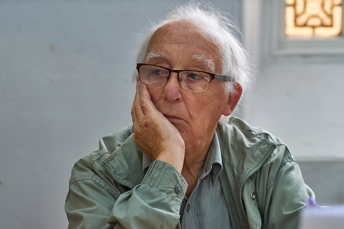 Elderly man sitting alone in thought.