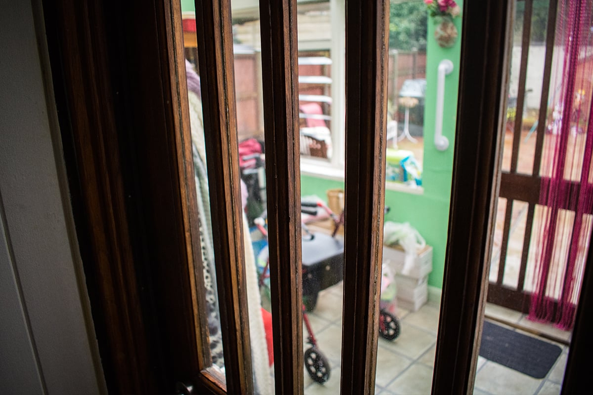 A home entrance with a grab rail and a rolling walker.