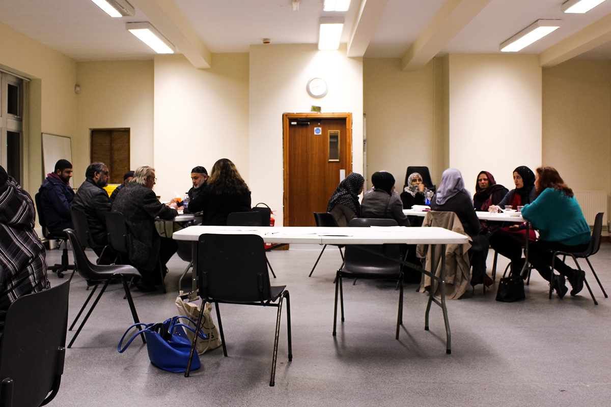 People seated at tables at job centre.