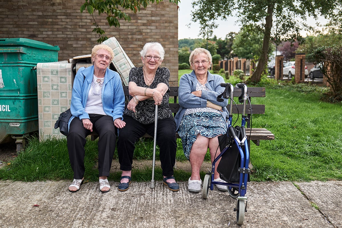Three ladies in later life sitting on a bench