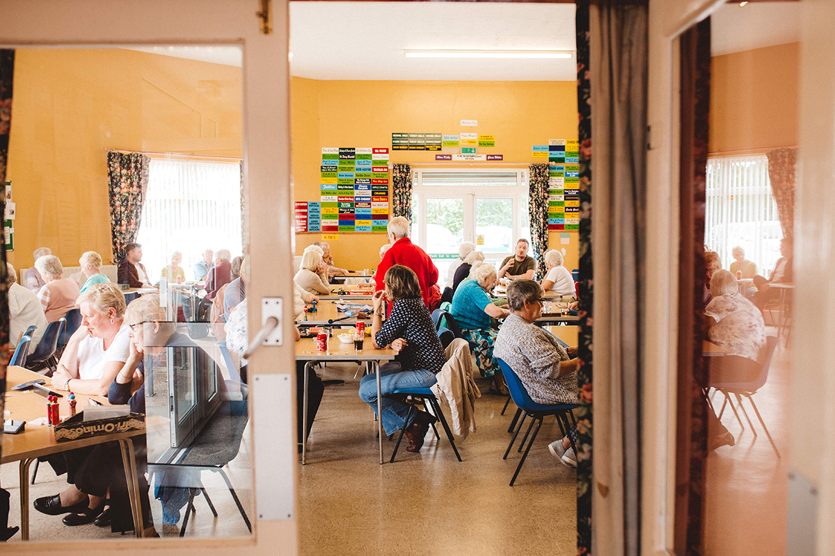 Group of older people sitting by tables