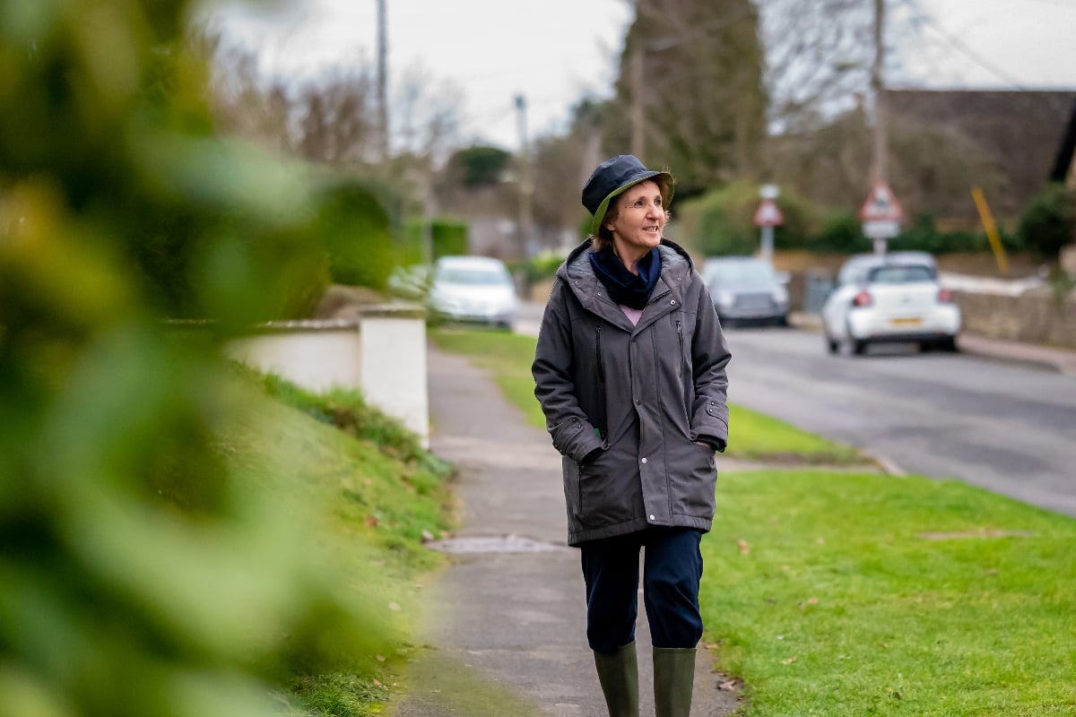 an older woman walking along a residential street