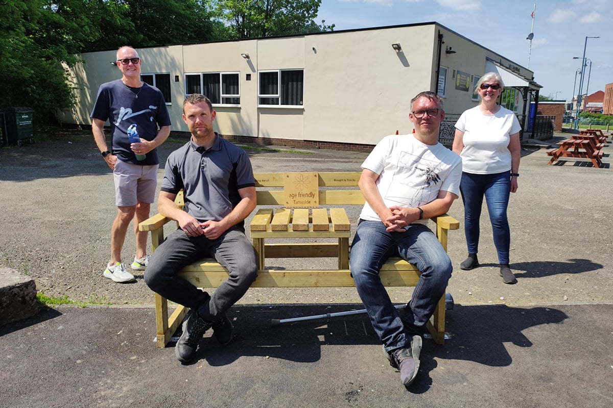 Two people sitting on an age-friendly bench