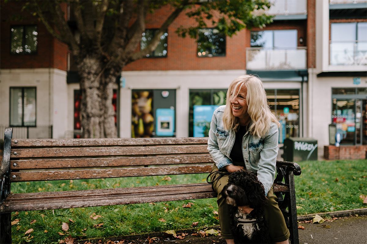 older woman sitting down with a dog