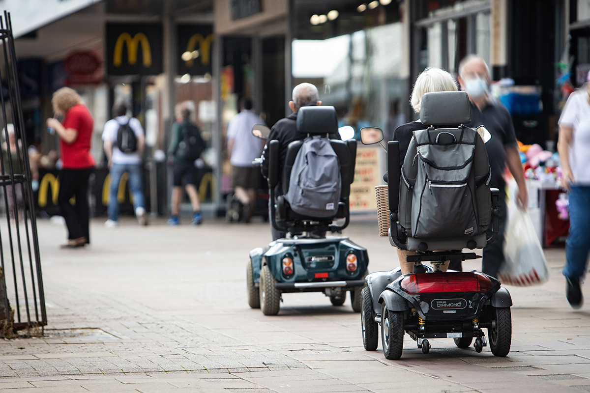 Older people on a mobility scooter on high street
