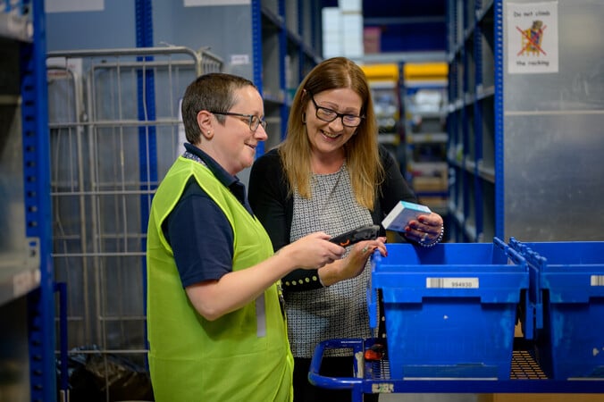 Two women examine products in a warehouse