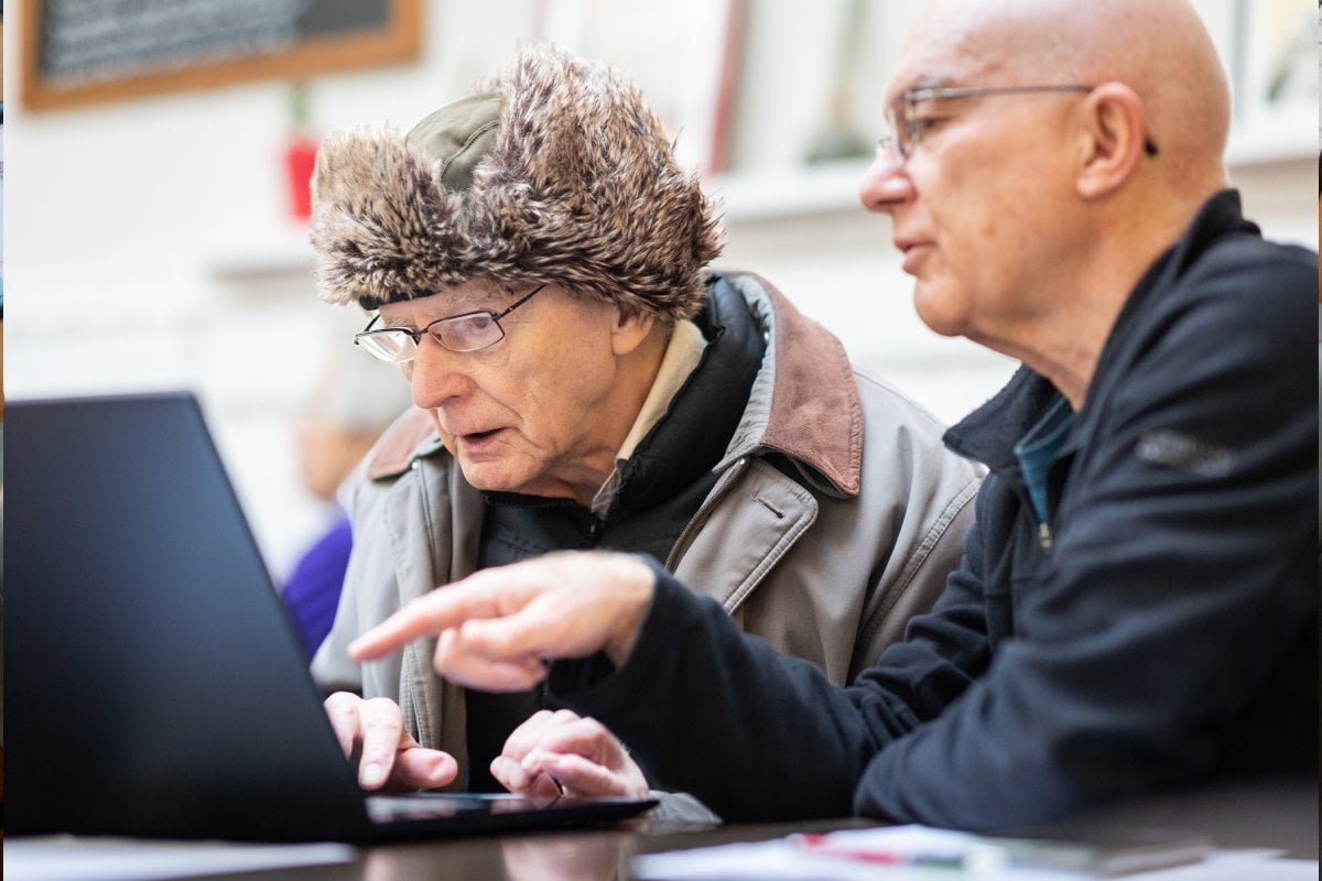 Two older men looking at a laptop