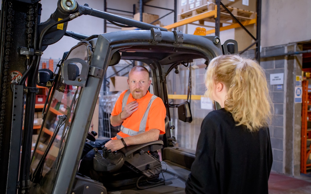 An older worker using a forklift