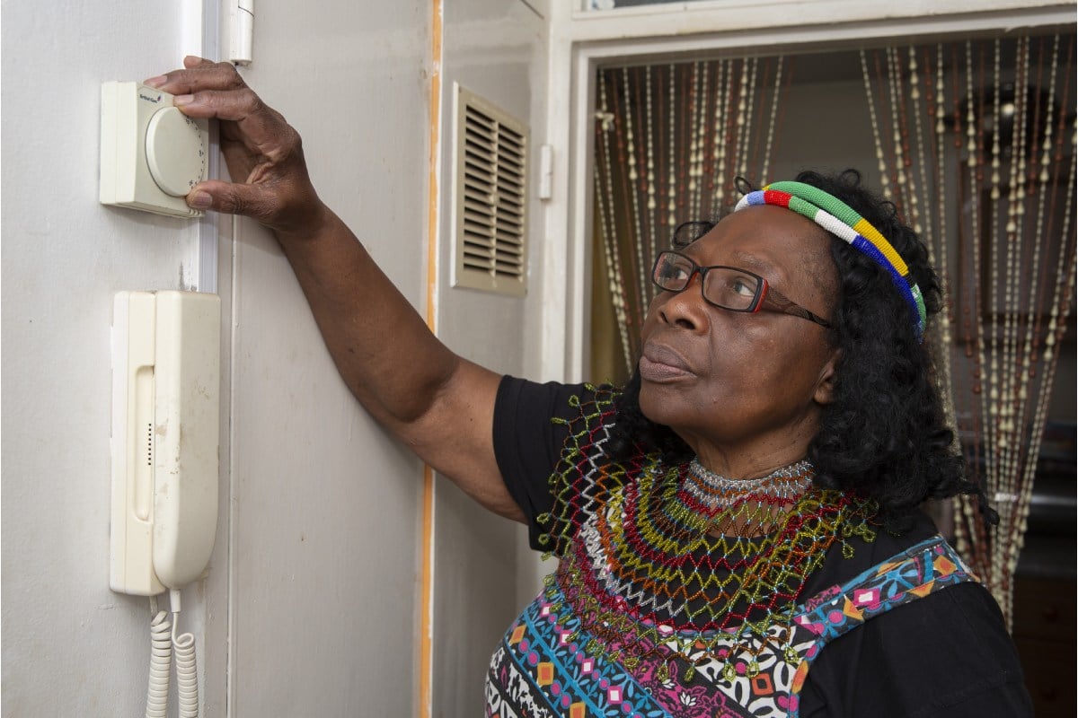 Older woman checking thermostat