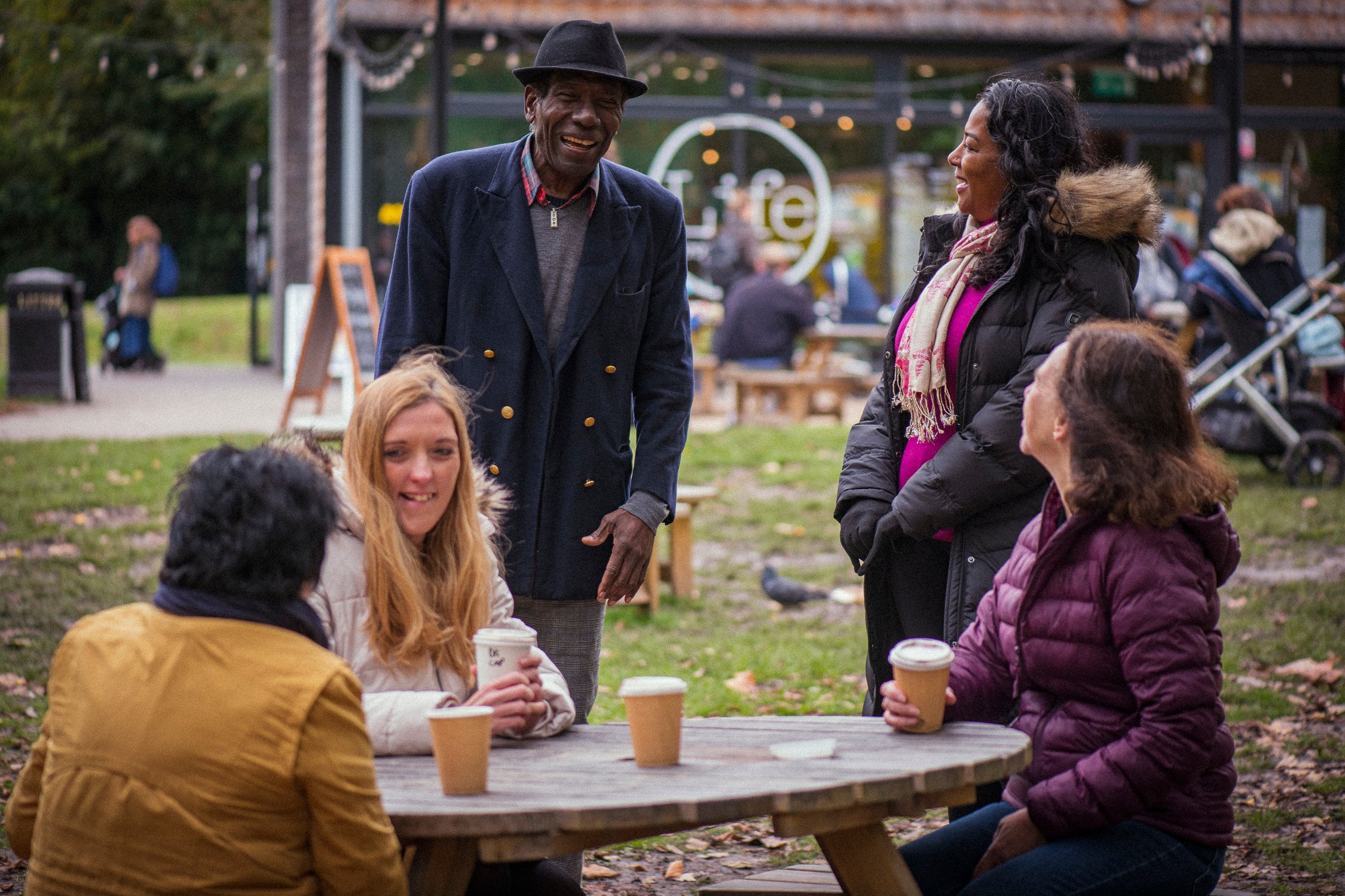 People sitting round the table having coffee and laughing