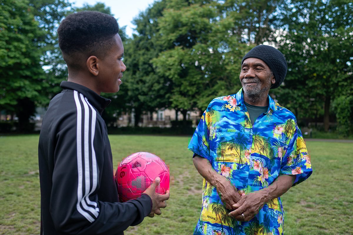 Older man playing football with his son