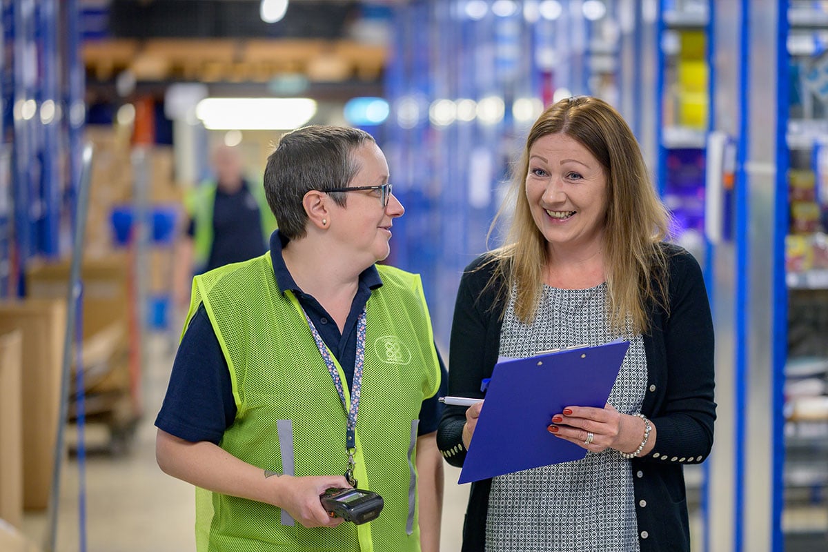 Two older women working with a clipboard