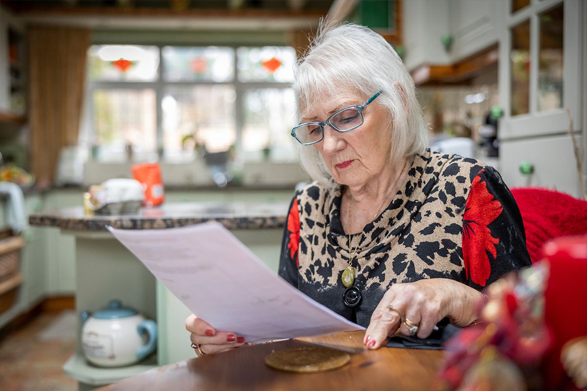 Older woman in home looking at papers