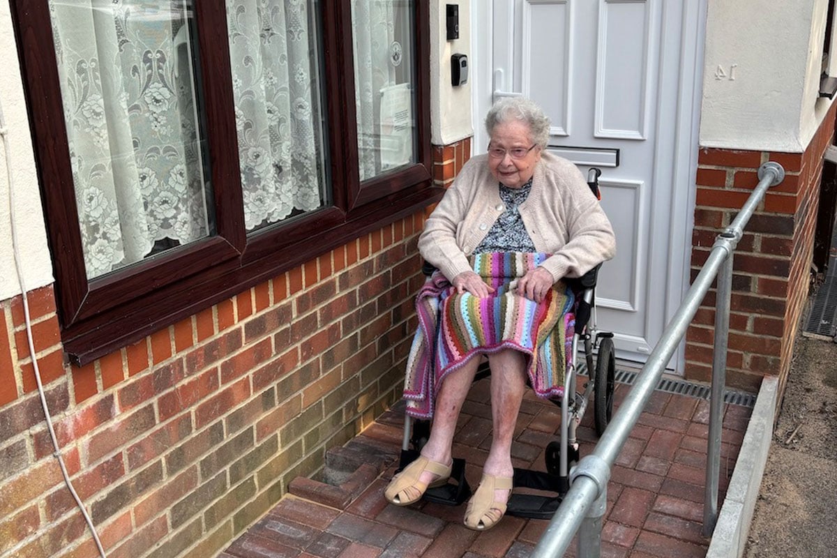 An-older-woman-in-a-wheelchair-in-front-of-her-house