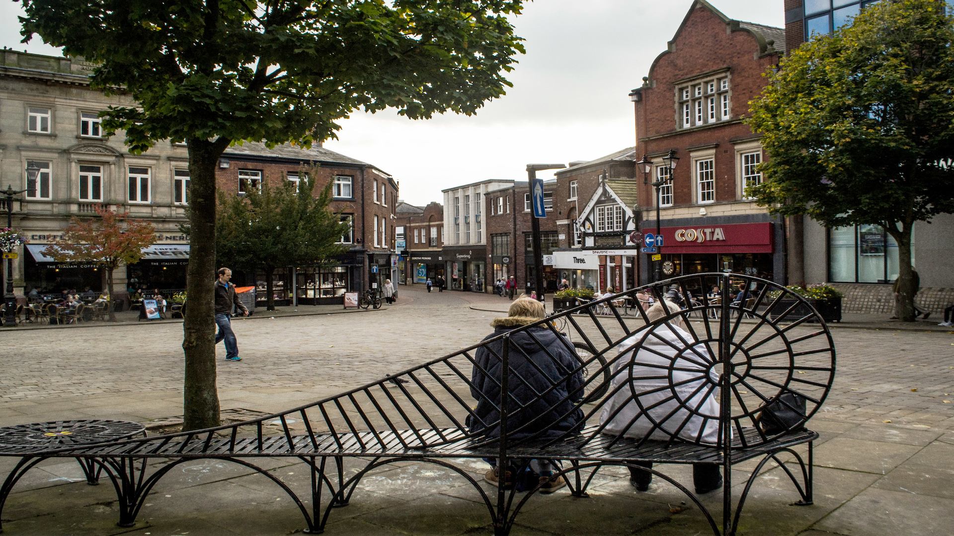 Two women sitting on a bench in Macclesfield