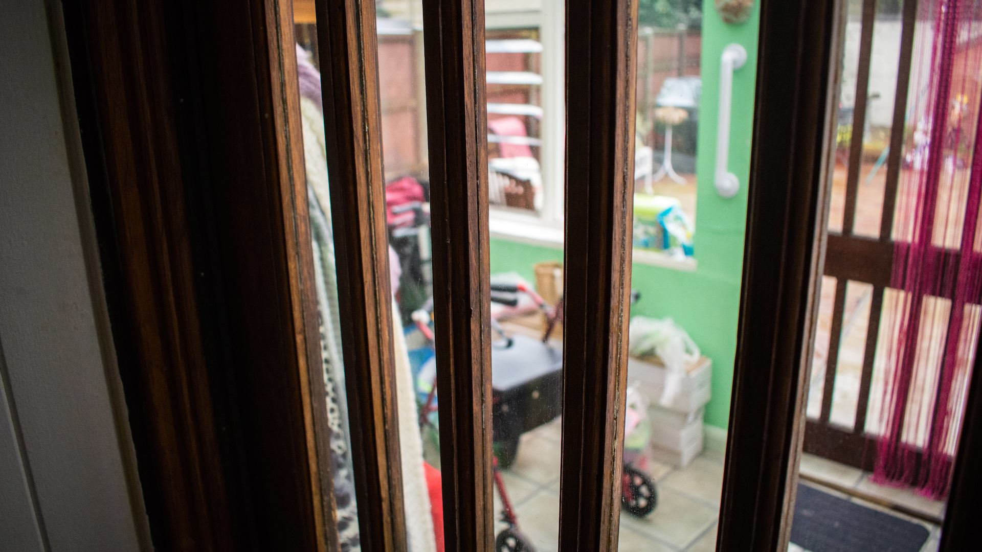 A home entrance with a grab rail and a rolling walker.