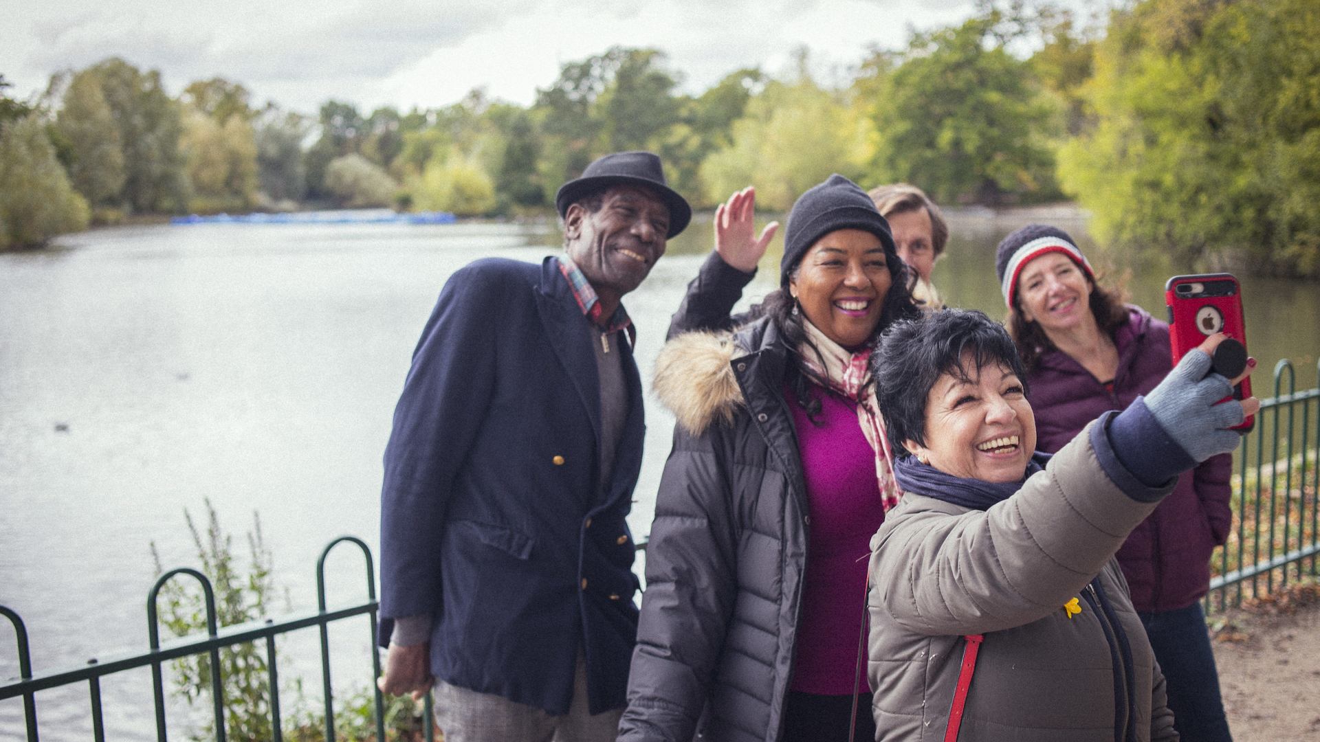 Older group of adults taking a selfie in front of a lake