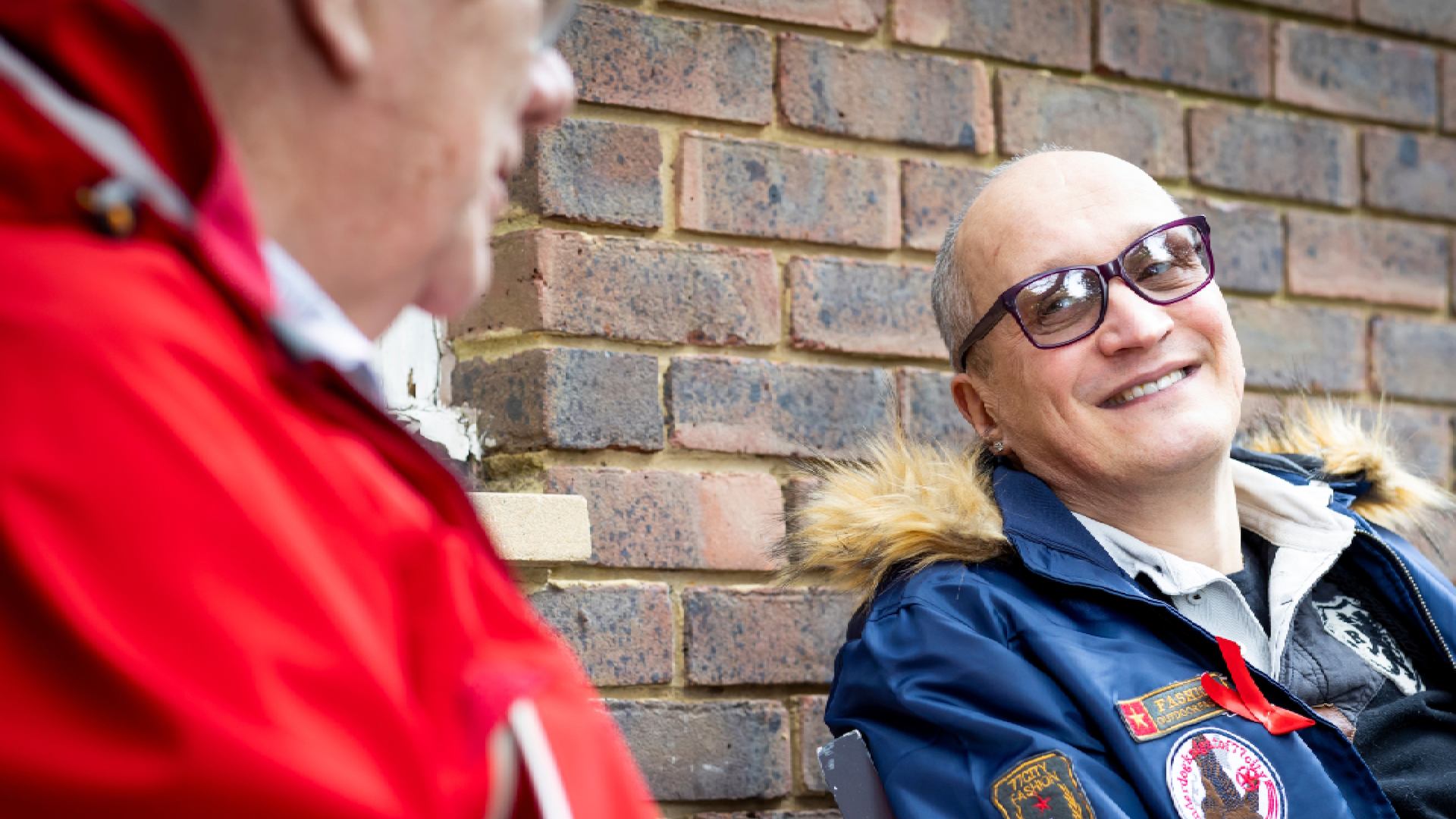 two men sitting outside talking