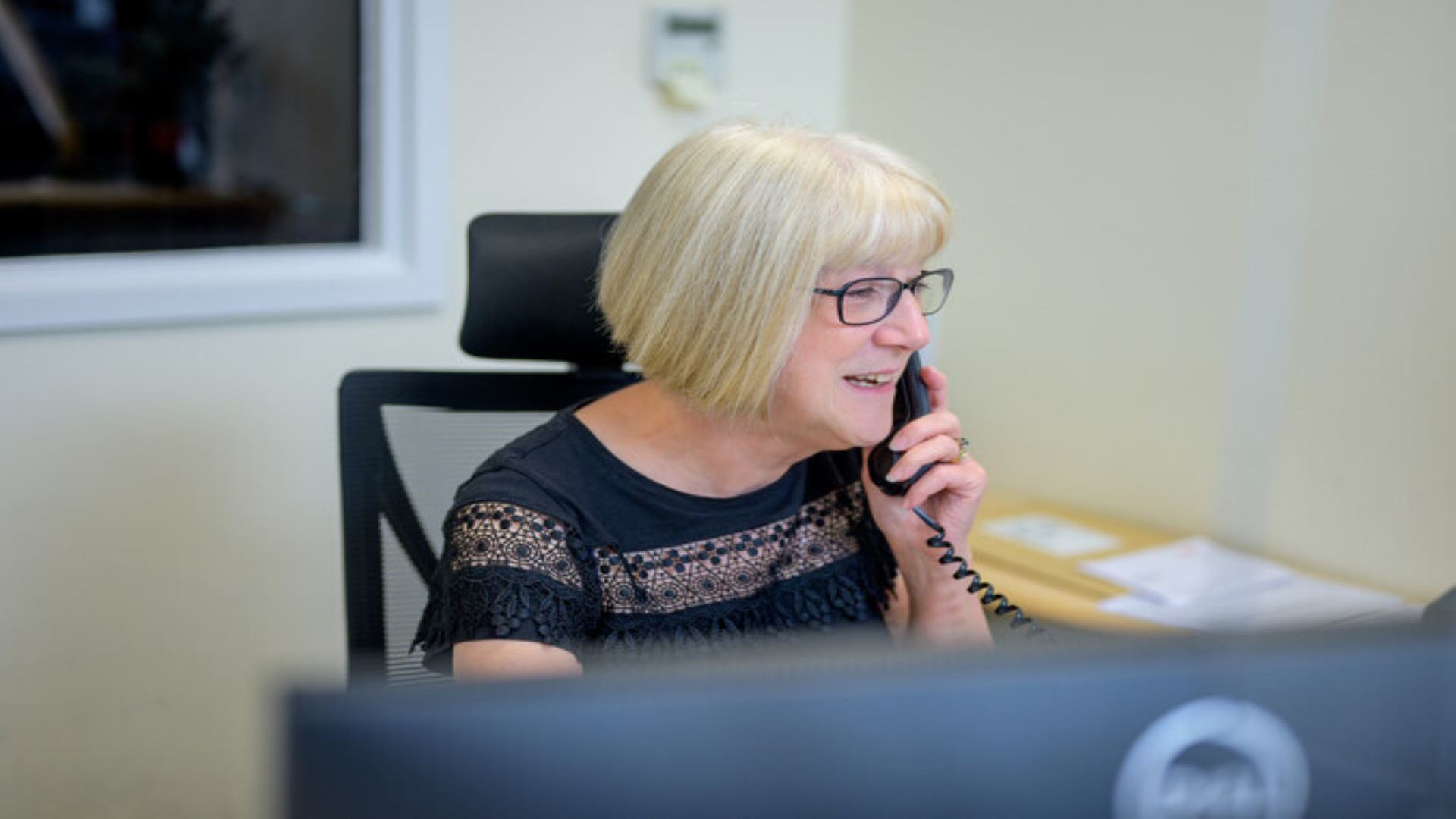 Image of a woman using a laptop on the phone
