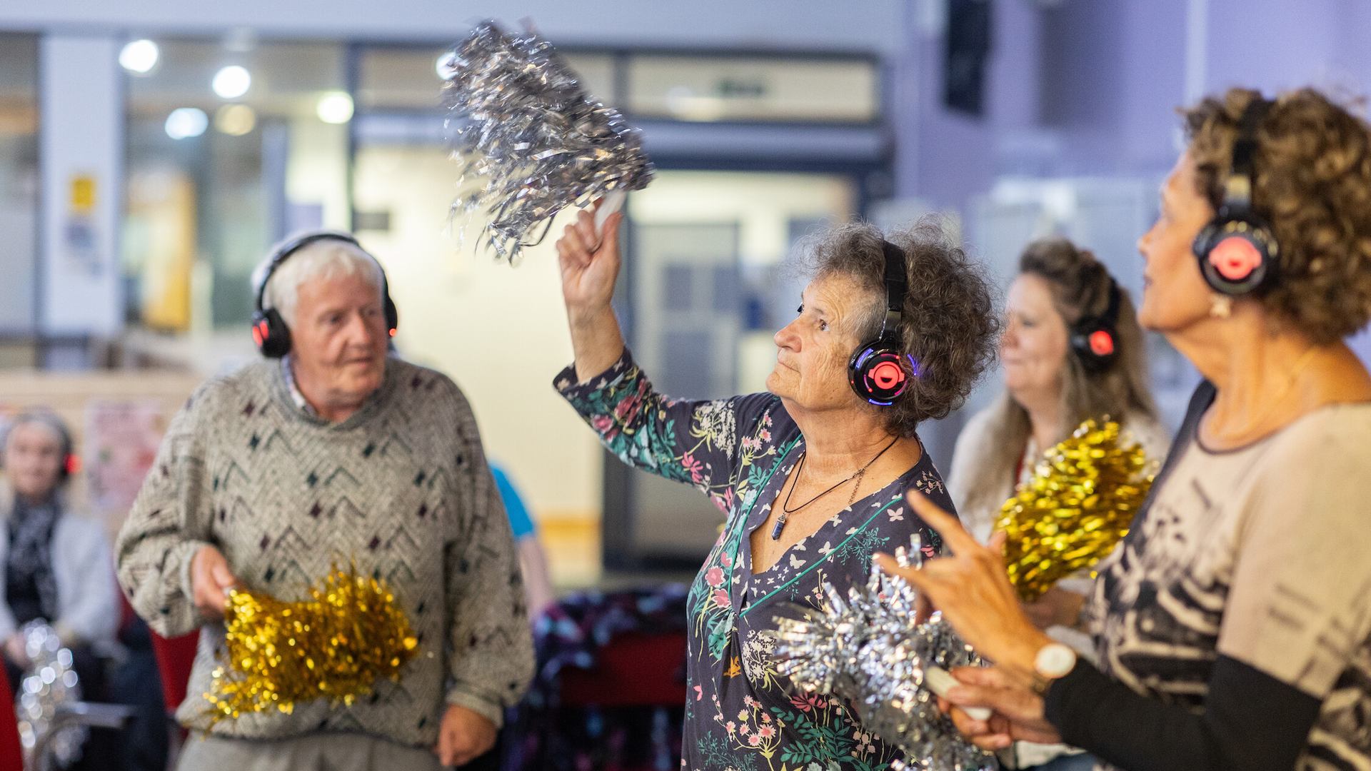 People dancing at silent disco with tinsel pompoms