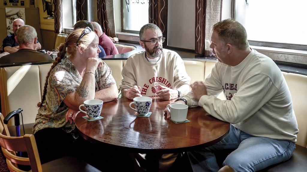 Three people talking around a table