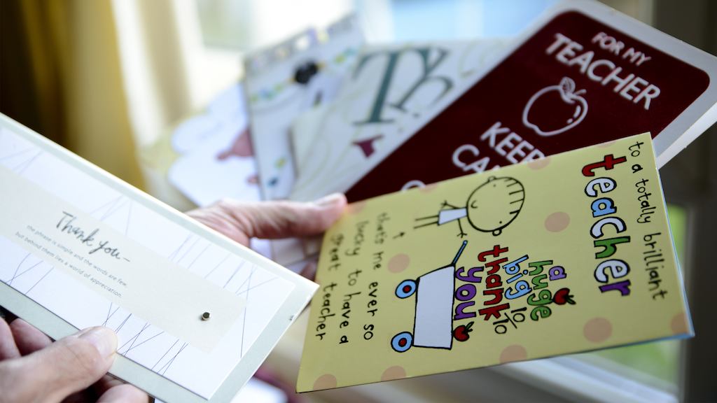 Teacher holding 'thank you' cards