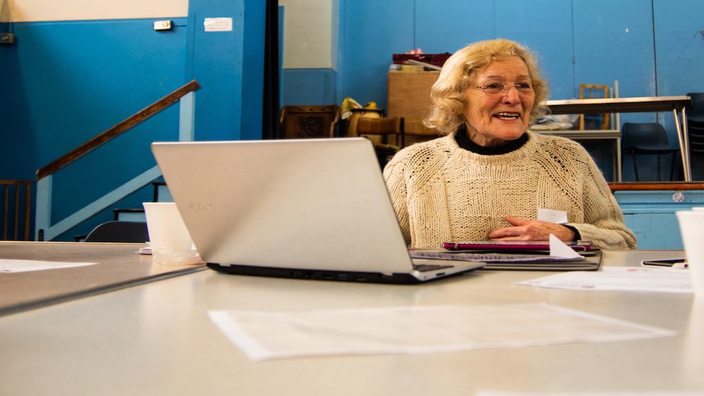 Woman seated at a table, using a laptop