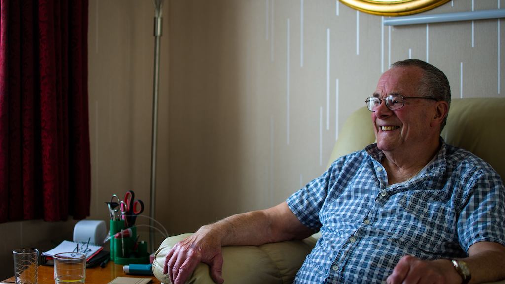Older man sitting on chair in home