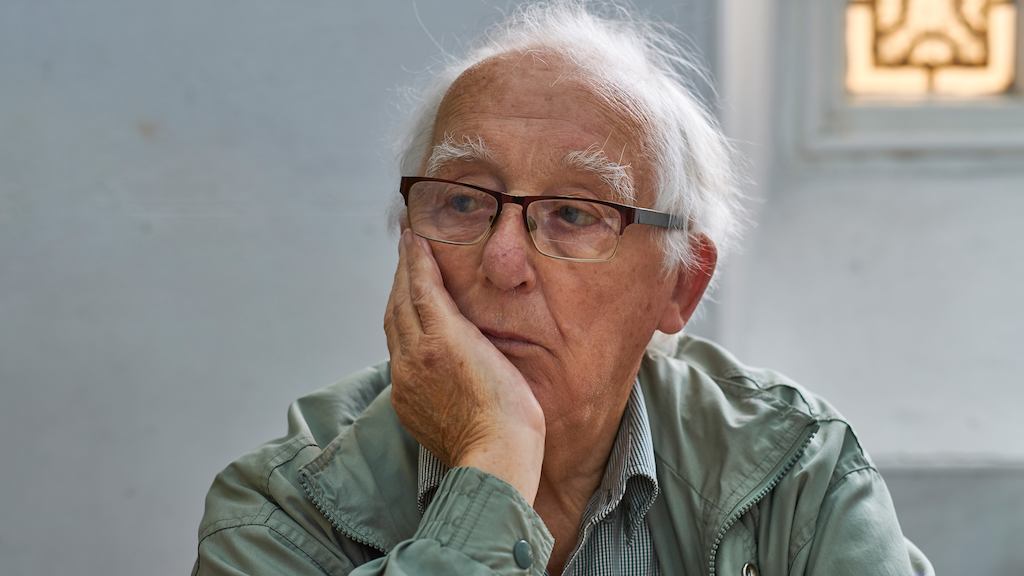 Elderly man sitting alone in thought.
