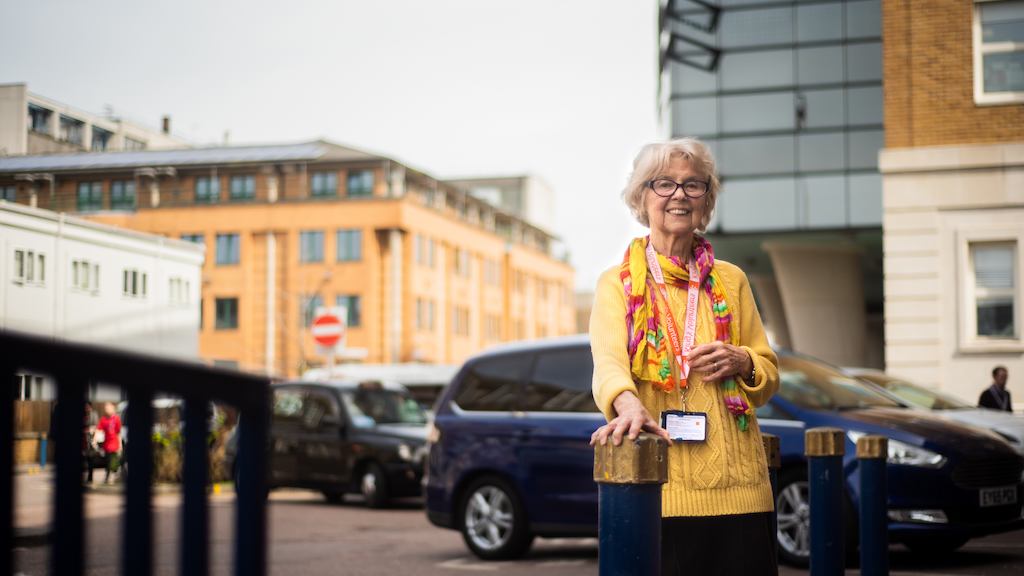 Older woman hospital volunteering standing outside hospital.