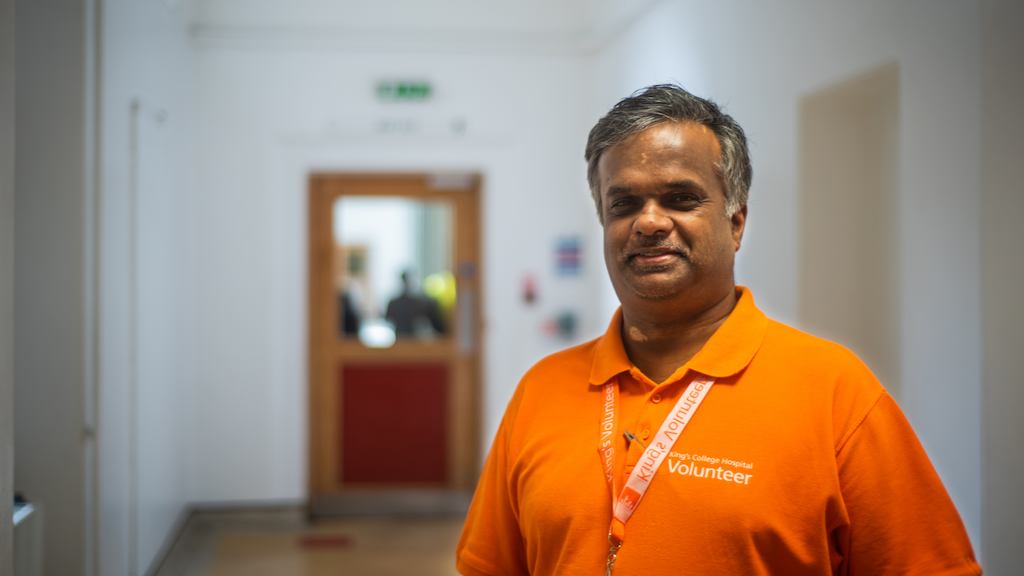 Older Indian male volunteer in hospital setting. 