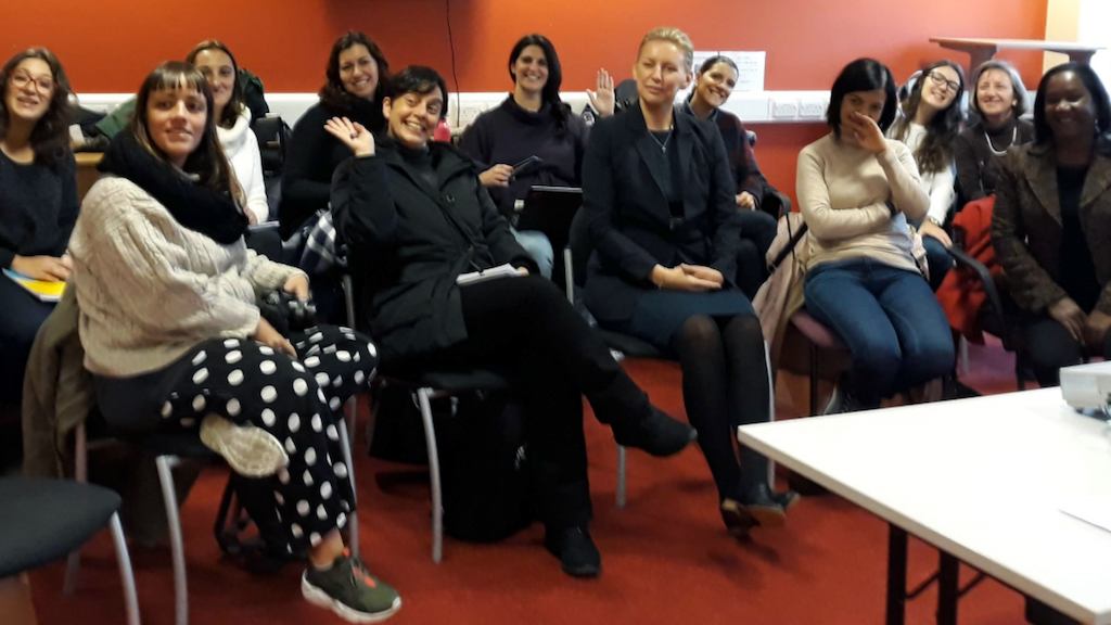 Women sitting in a room for a conference.