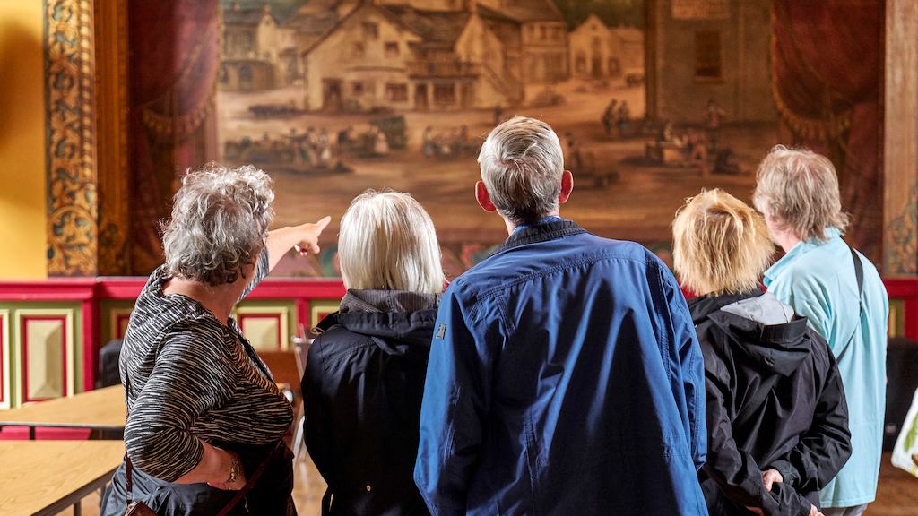 Group of elderly people in a museum looking at a work.