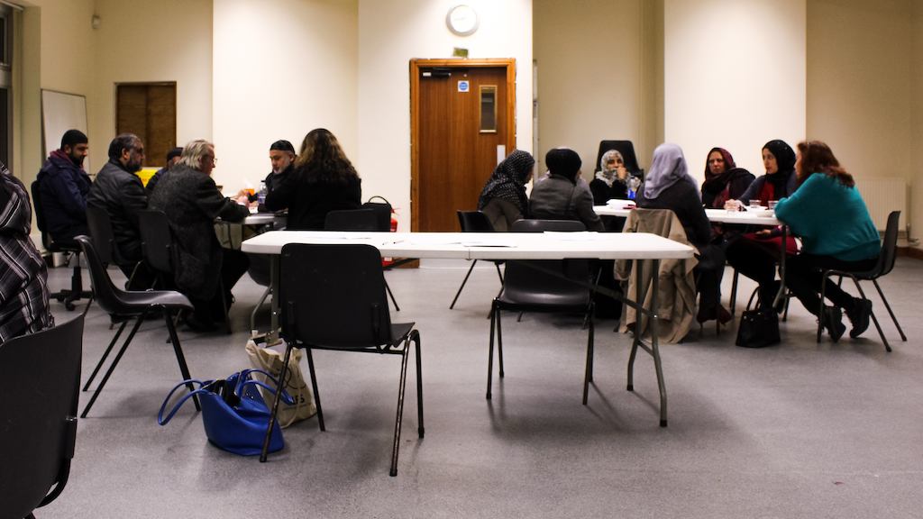 People seated at tables at job centre.
