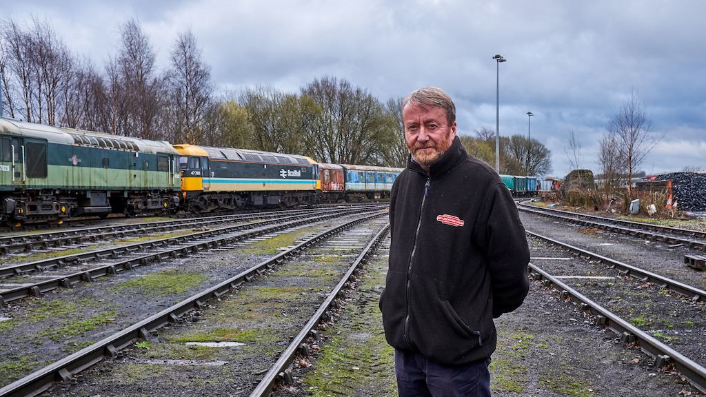 Older man standing by railway