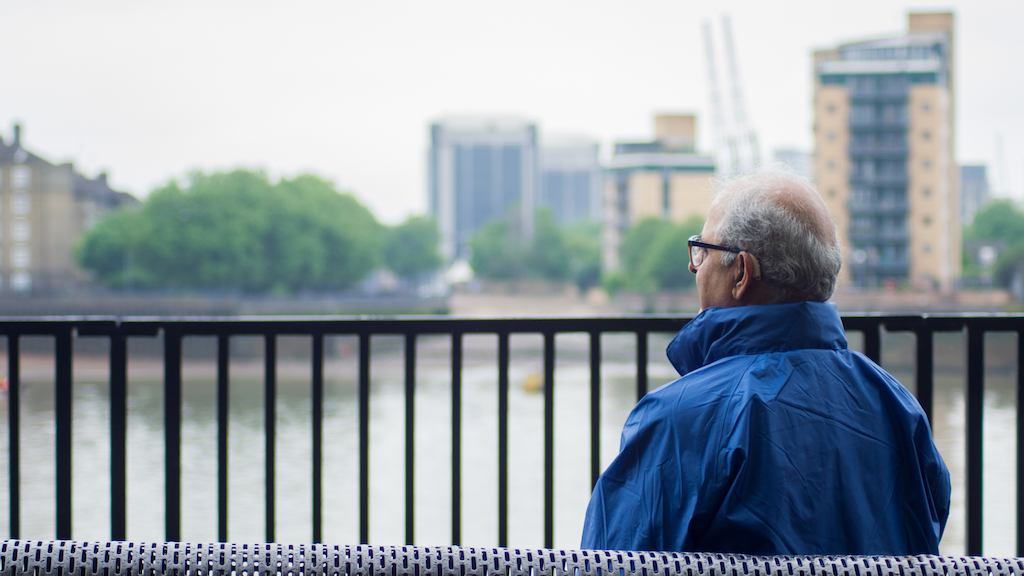 Older Asian man sitting on a bench
