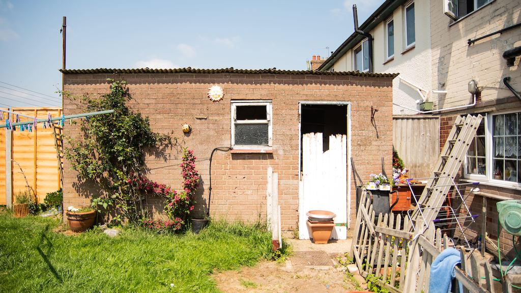 a sunny back garden that has lots of equipment in it