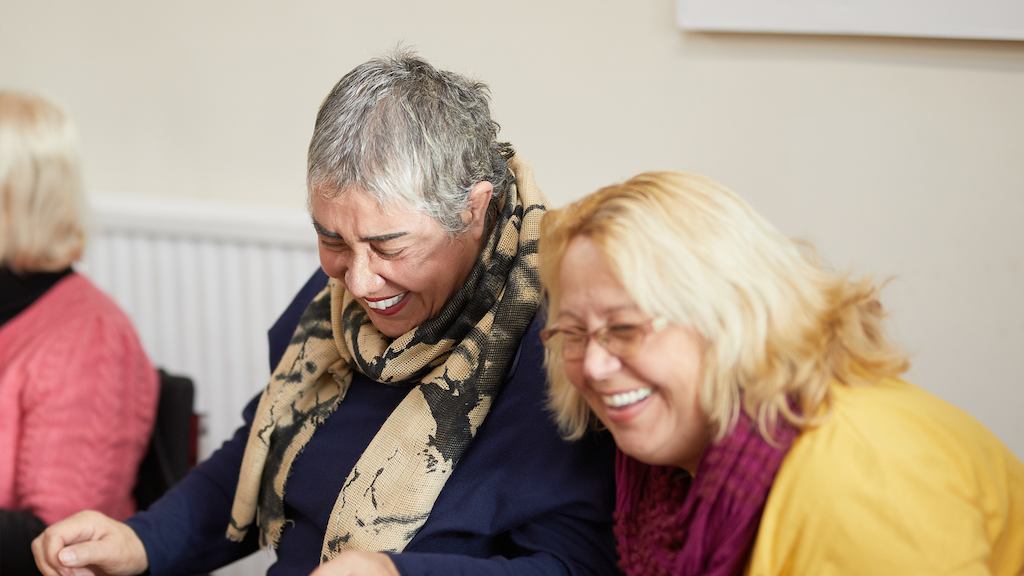 two female volunteers laughing mid-conversation