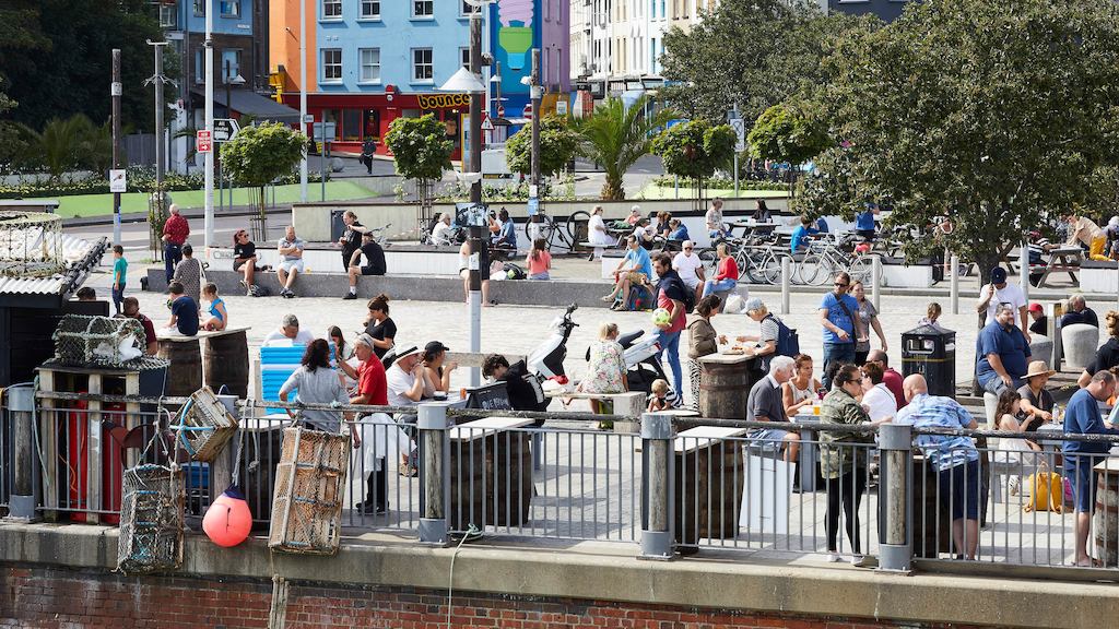 Group of people enjoying the sun by a bridge