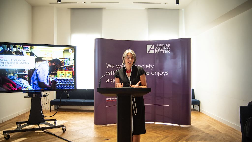 Anna Dixon on a podium giving a speech