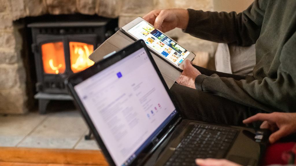 Older couple interacting with tablet and laptop