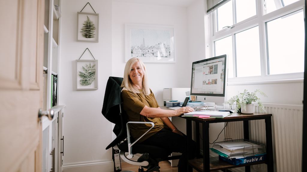 Older worker sitting by desk