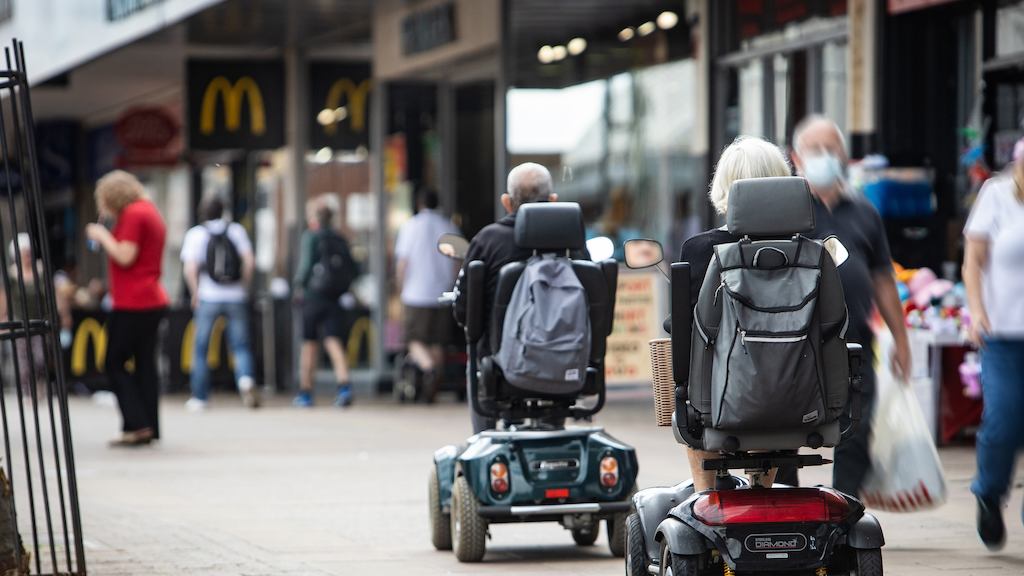 Older people on a mobility scooter on high street