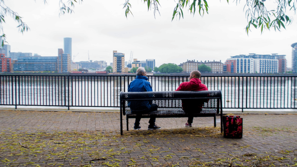 two BAME people sitting on a bench